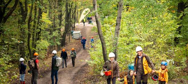 Familien mit Helmen in Wald
